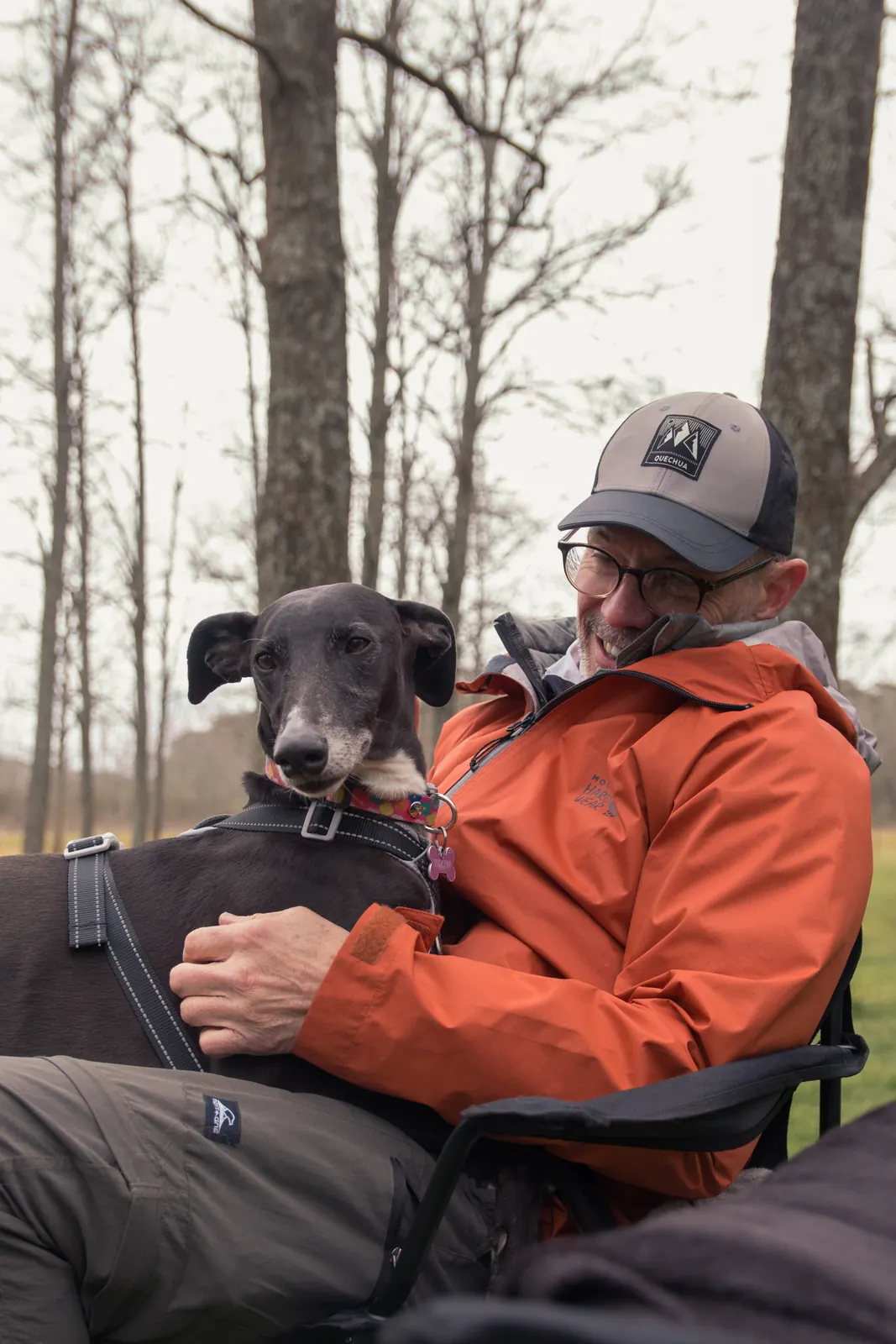 Hombre con su perro en brazos en el campamento