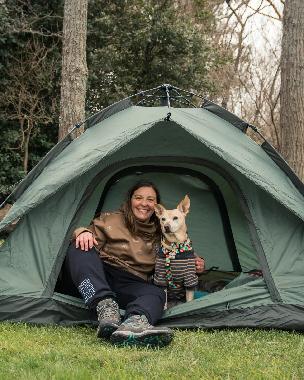 Mujer y su perro en la entrada de la carpa